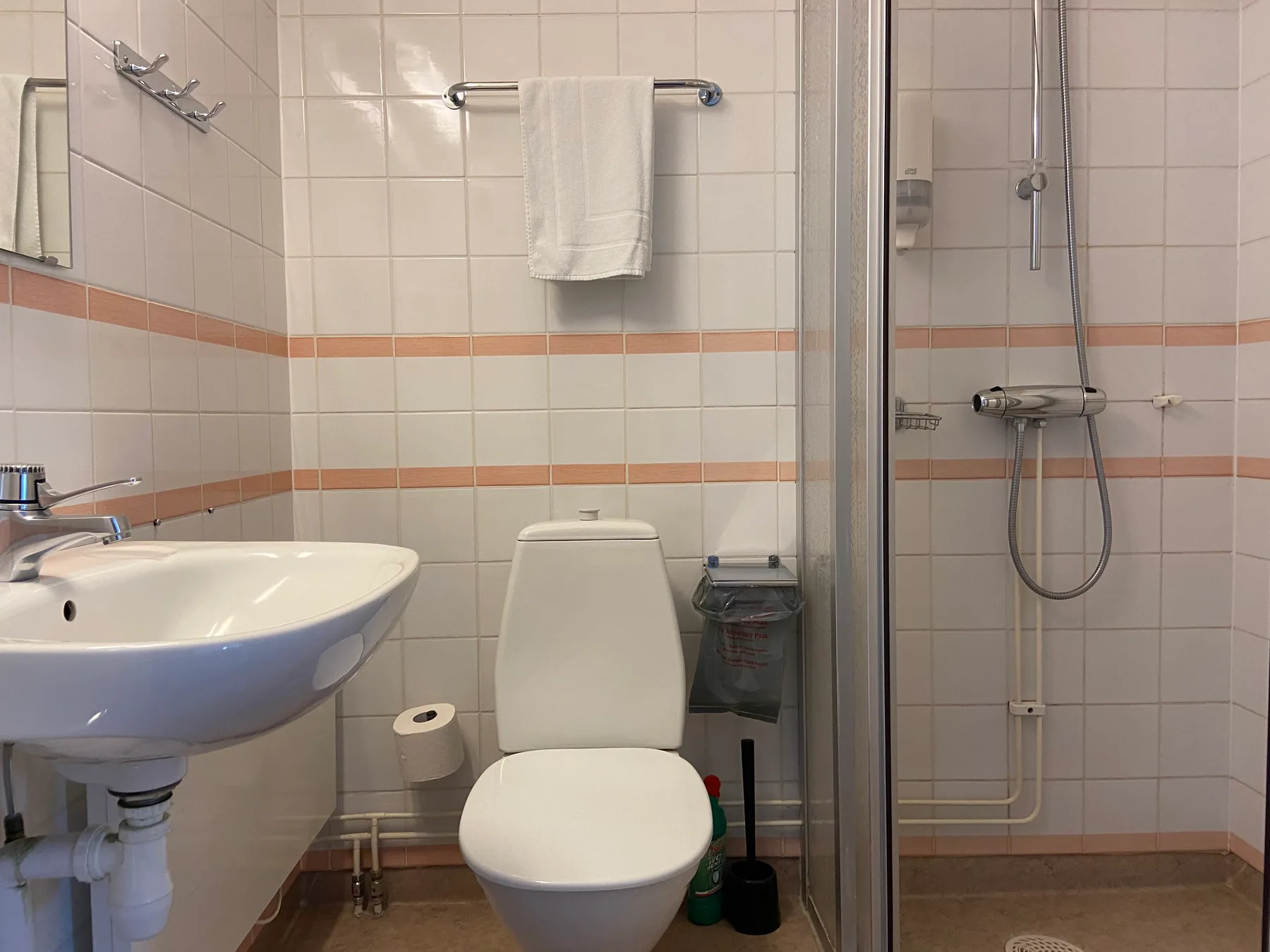 Hotellbadrum med handfat, toalett och dusch