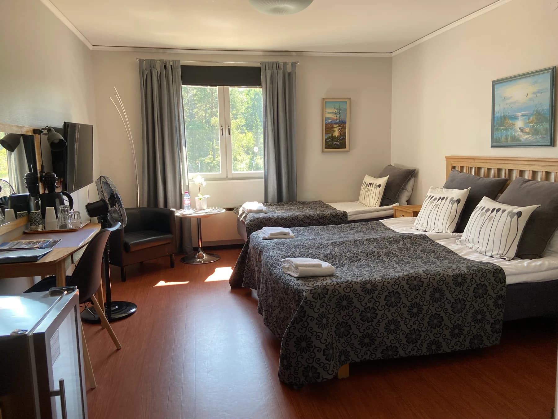 Hotellrum med dubbelsäng, fåtöljer och skrivbord